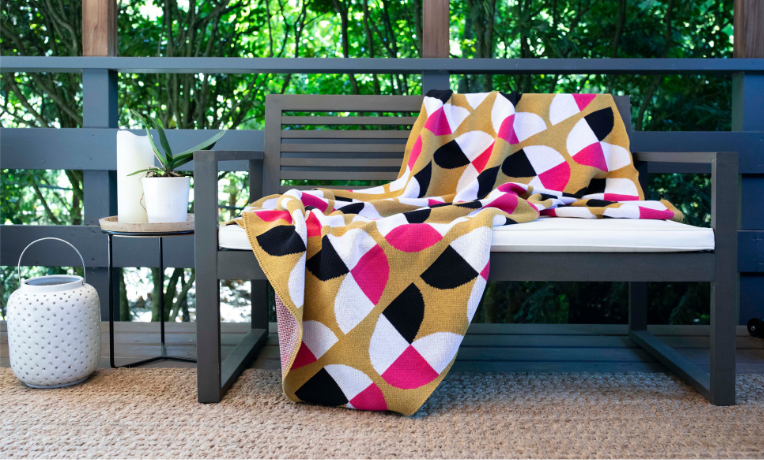 Seek & Swoon Bloem Throw Blanket on a bench on a patio